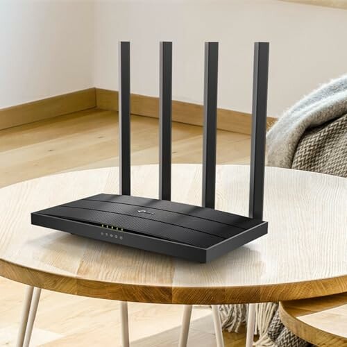 Modern WiFi router with four antennas on a wooden table.