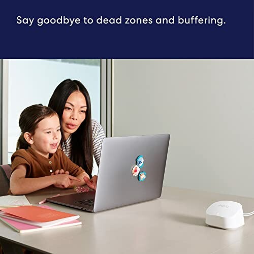 Mother and daughter using a laptop with a WiFi router nearby, text: 'Say goodbye to dead zones and buffering.'